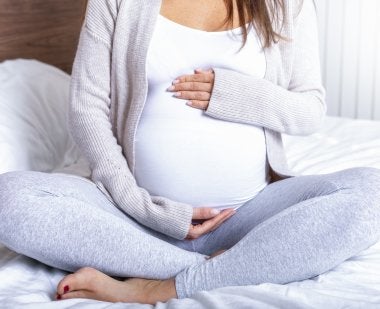 pregnant woman cradling belly