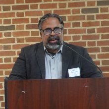 Neil Dhingra Ph.D. ’25, a graduate academic advisor in the UMD College of Information who holds a doctorate in education policy from UMD, speaks at a podium at the "Who Has the Power? The Constitution and Our Role in Securing Democracy” event.