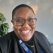 Tyanna A.E. Clayton-Mallett, a Ph.D. candidate, wearing a blue lanyard as a docent at the National Museum of African American History and Culture.