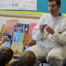 Bee keeper talking with children