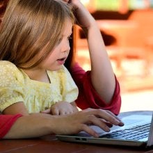 Image of child and parent on laptop