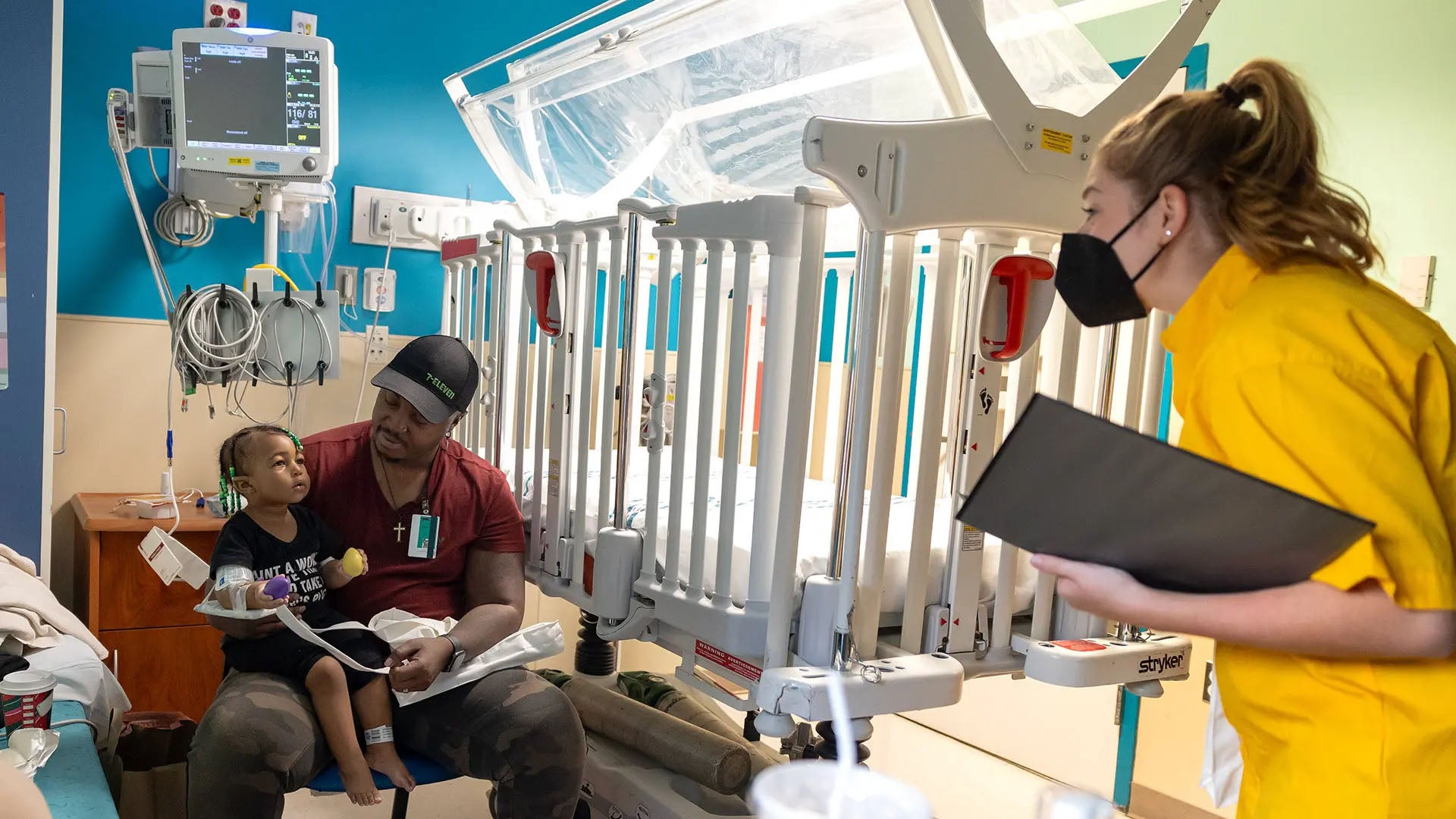 Music education major Paige Peercy ’25 (right) sings to a young patient and her father at University of Maryland Children's Hospital in Baltimore. Photo by Riley Sims Ph.D. '23