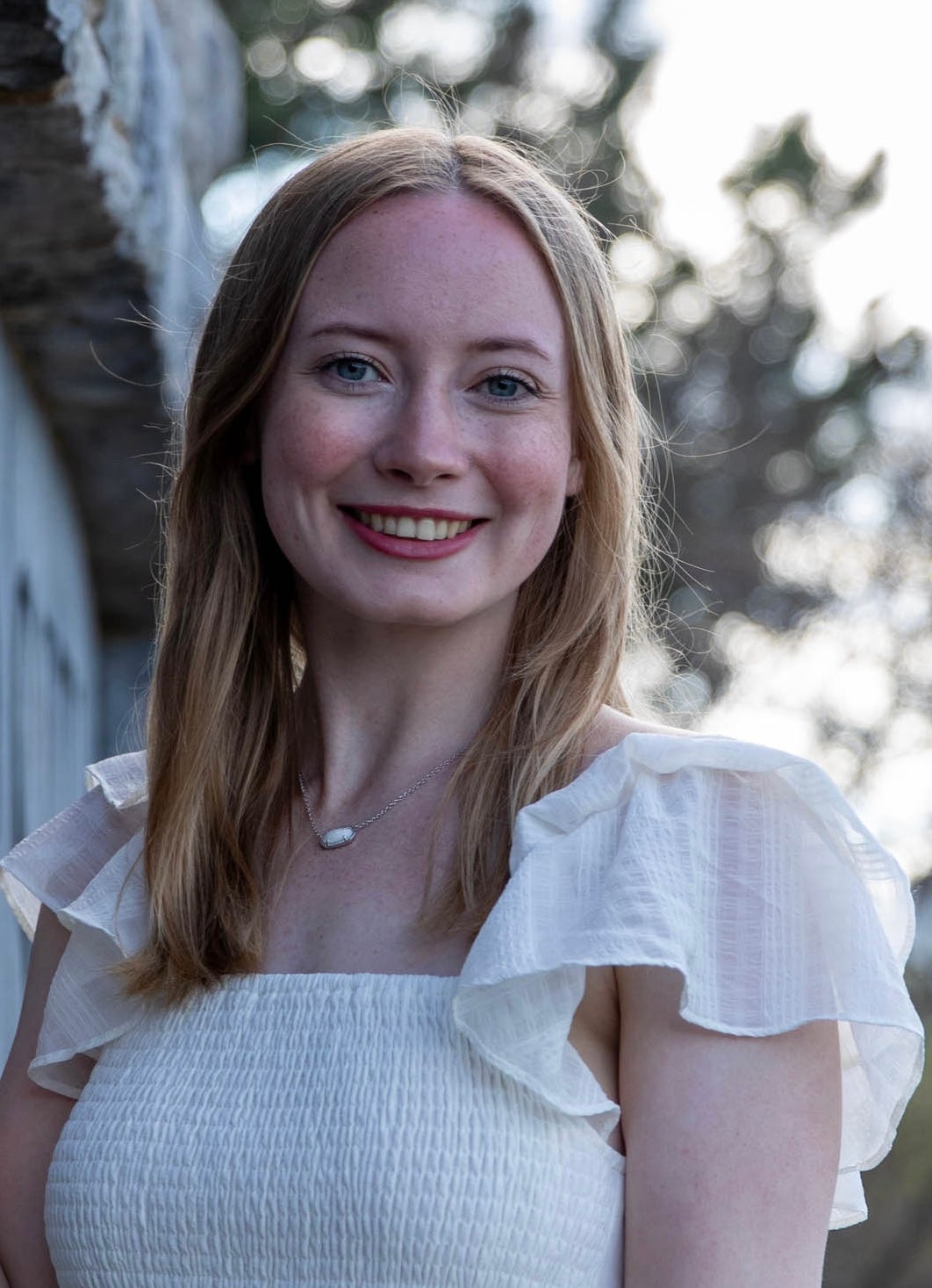 white woman, blonde hair, smiling, white shirt