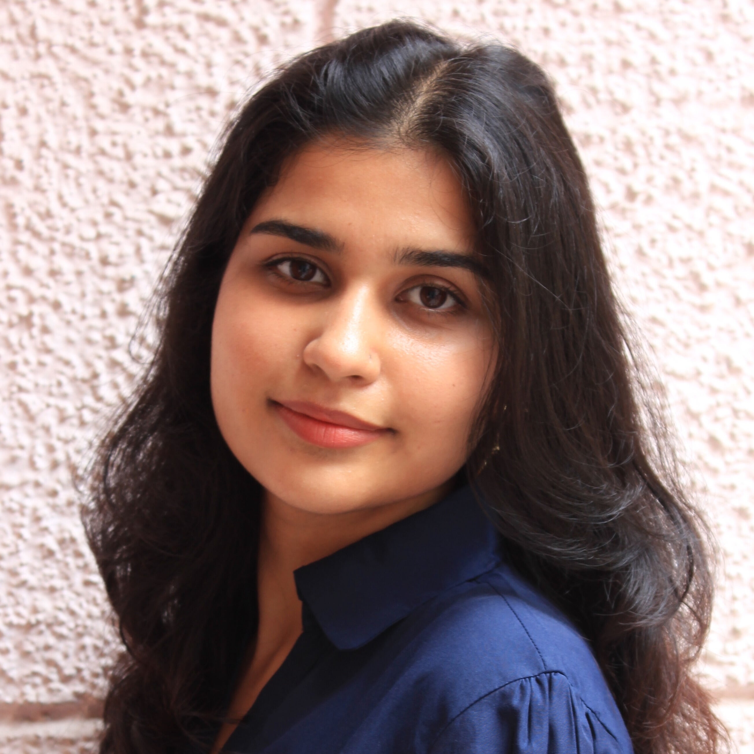 Indian woman, long black hair, blue shirt, partial smile