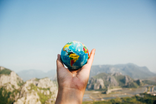 hand holding a small globe