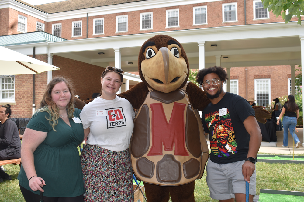 3 people taking a picture with the Testudo mascot