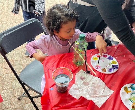 Girl painting DIY bird feeder at Maryland Day