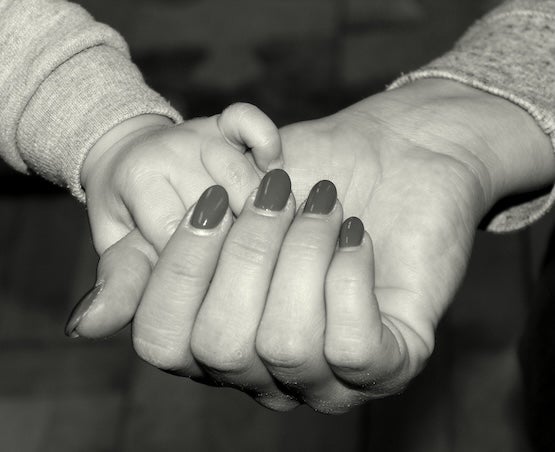 Child and adult holding hands