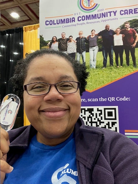 Woman standing near a table at an event promoting her business