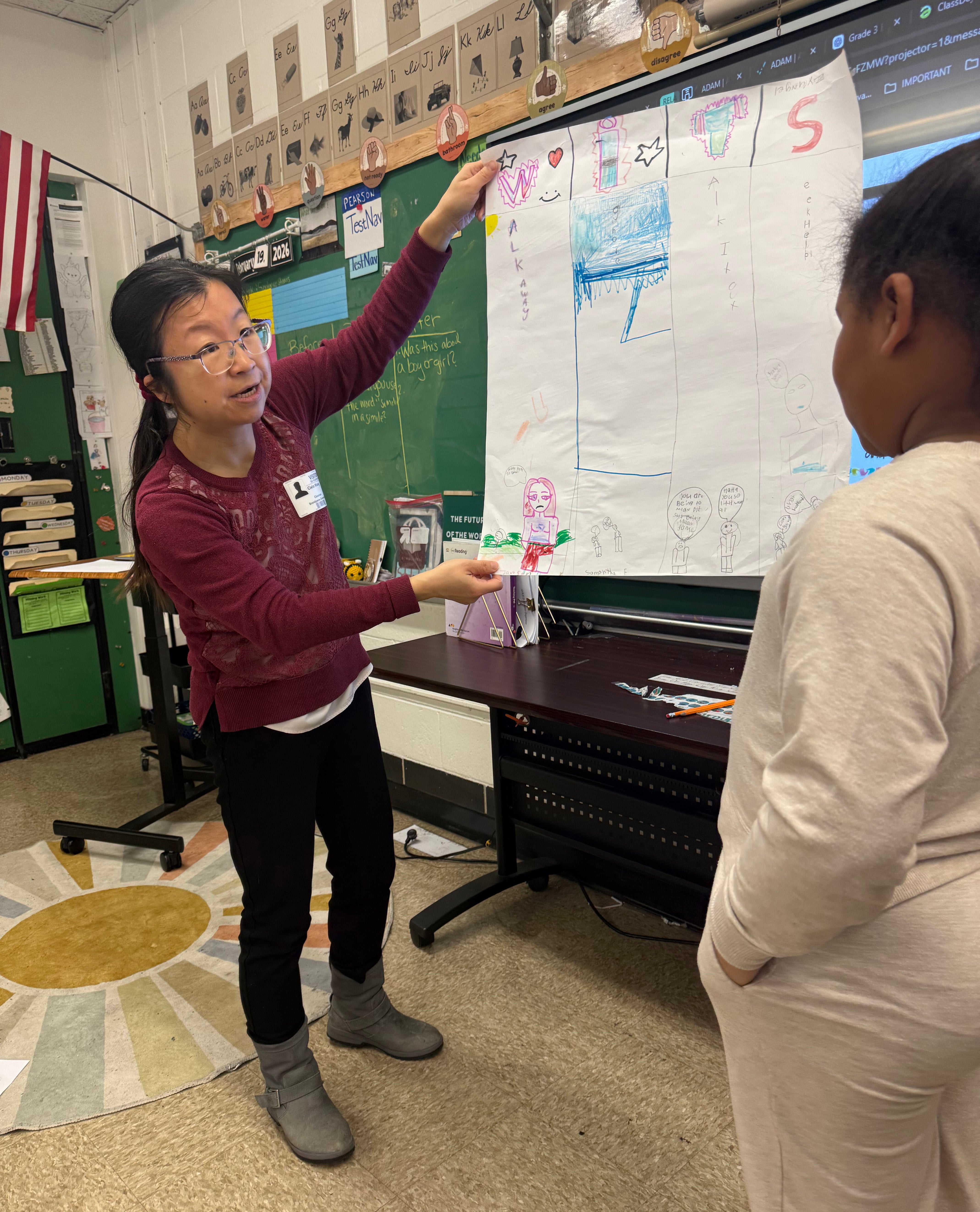 Associate Professor Cixin Wang holds a poster a third grader created at Brandywine Elementary School as part of the Bullying Literature Project.