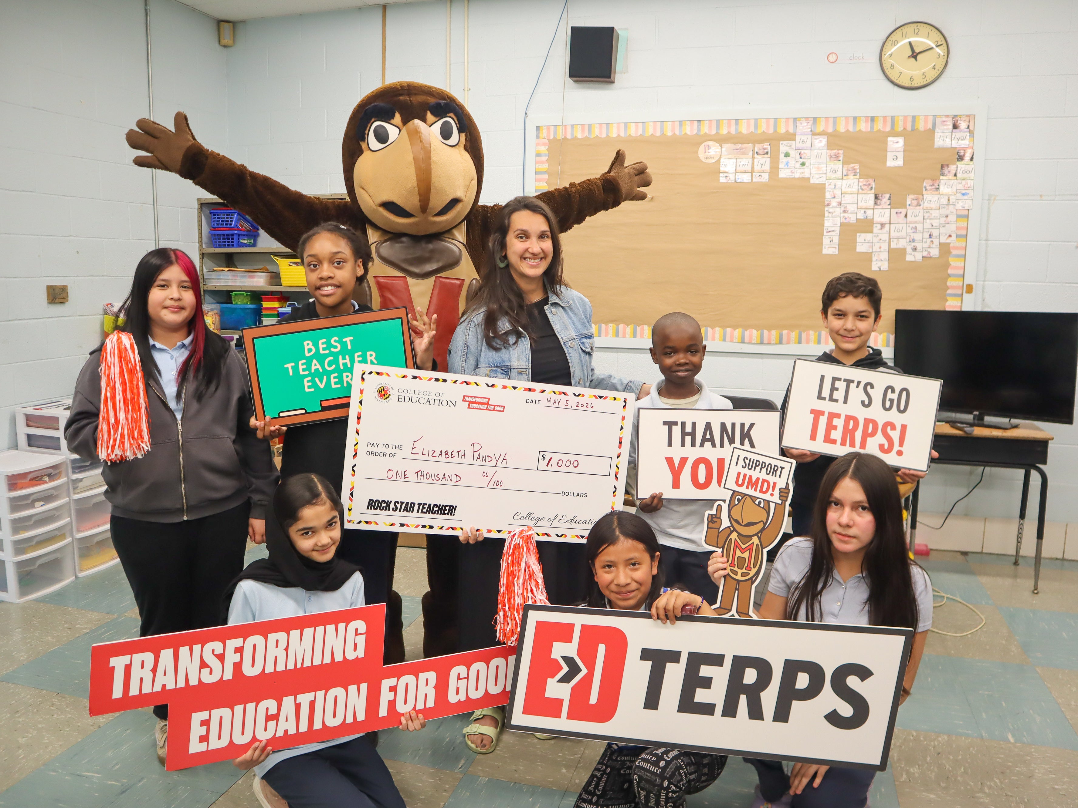 Surrounded by her students, English Language Development teacher Elizabeth Pandya ’14, M.P.P. ’16, M.Ed. ’21, holds a $1,000 check from the College of Education during a surprise school visit for Teacher Appreciation Week.