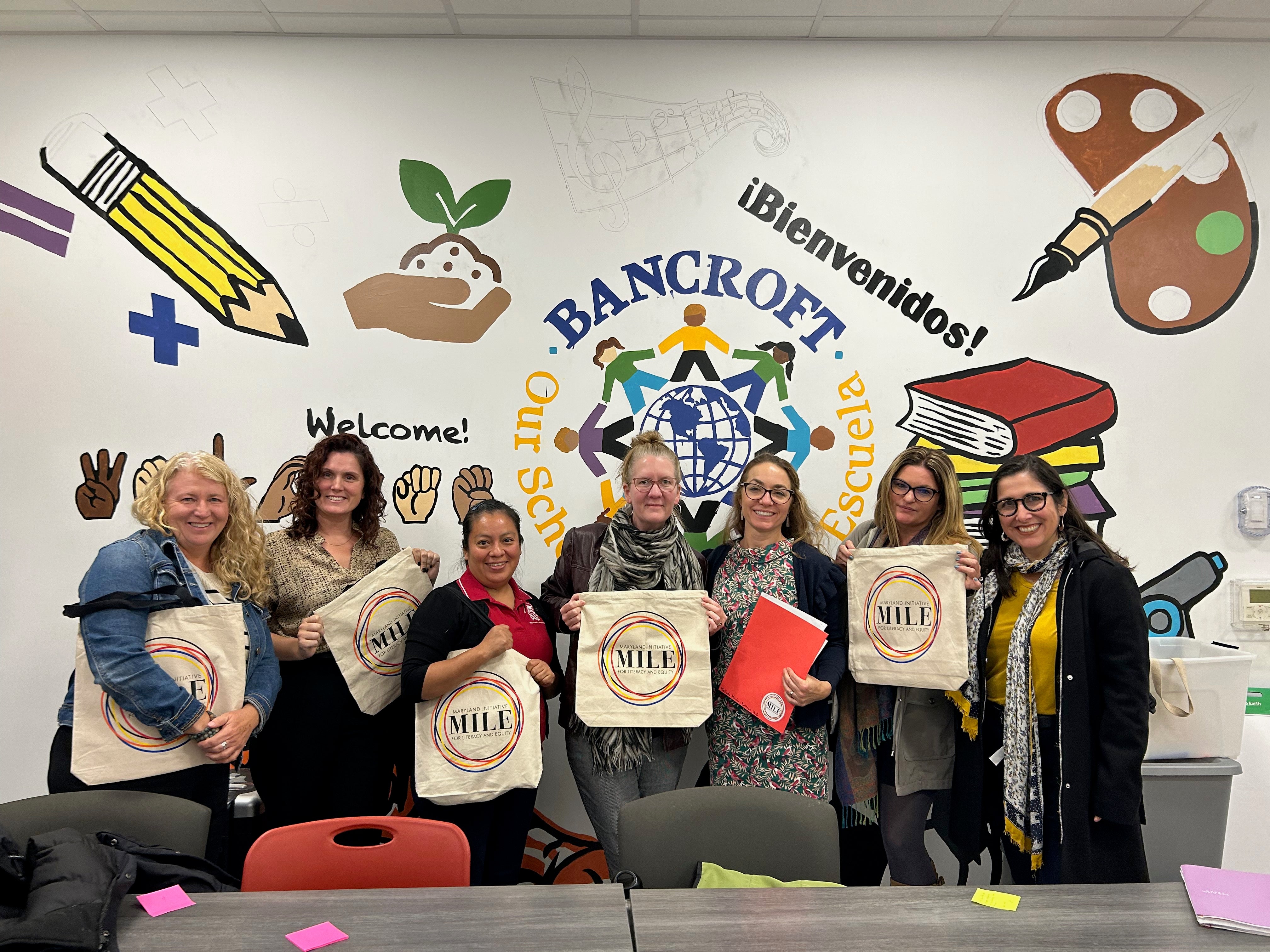Teachers stand together with MILE totes