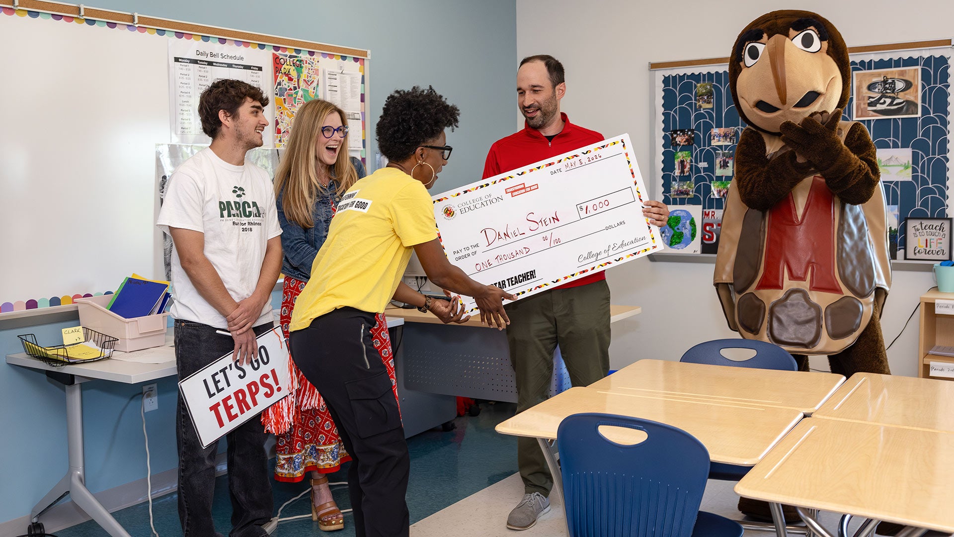 Dean Kimberly Griffin presents a $1,000 check to modern world history teacher Daniel Stein ’16 during a surprise school visit for Teacher Appreciation Week.