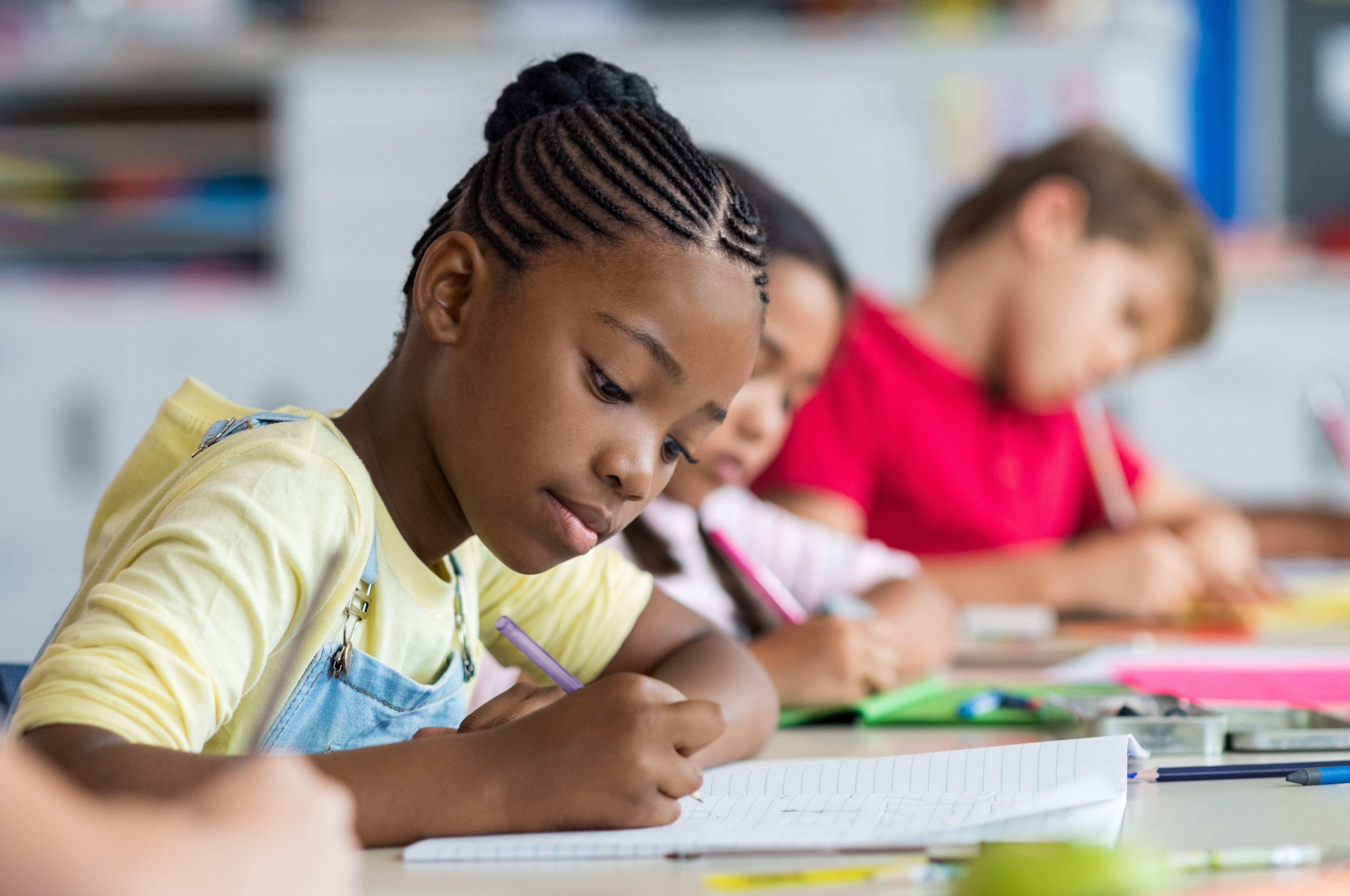 Student writing at desk