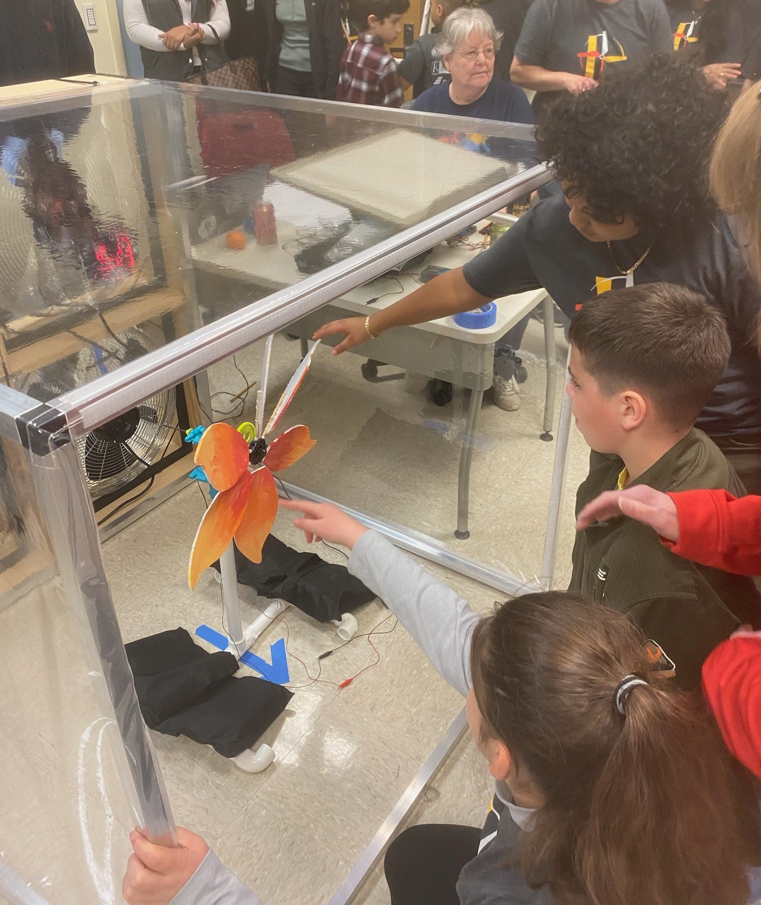 Students testing a wind turbine in a KidWind Competition Tunnel