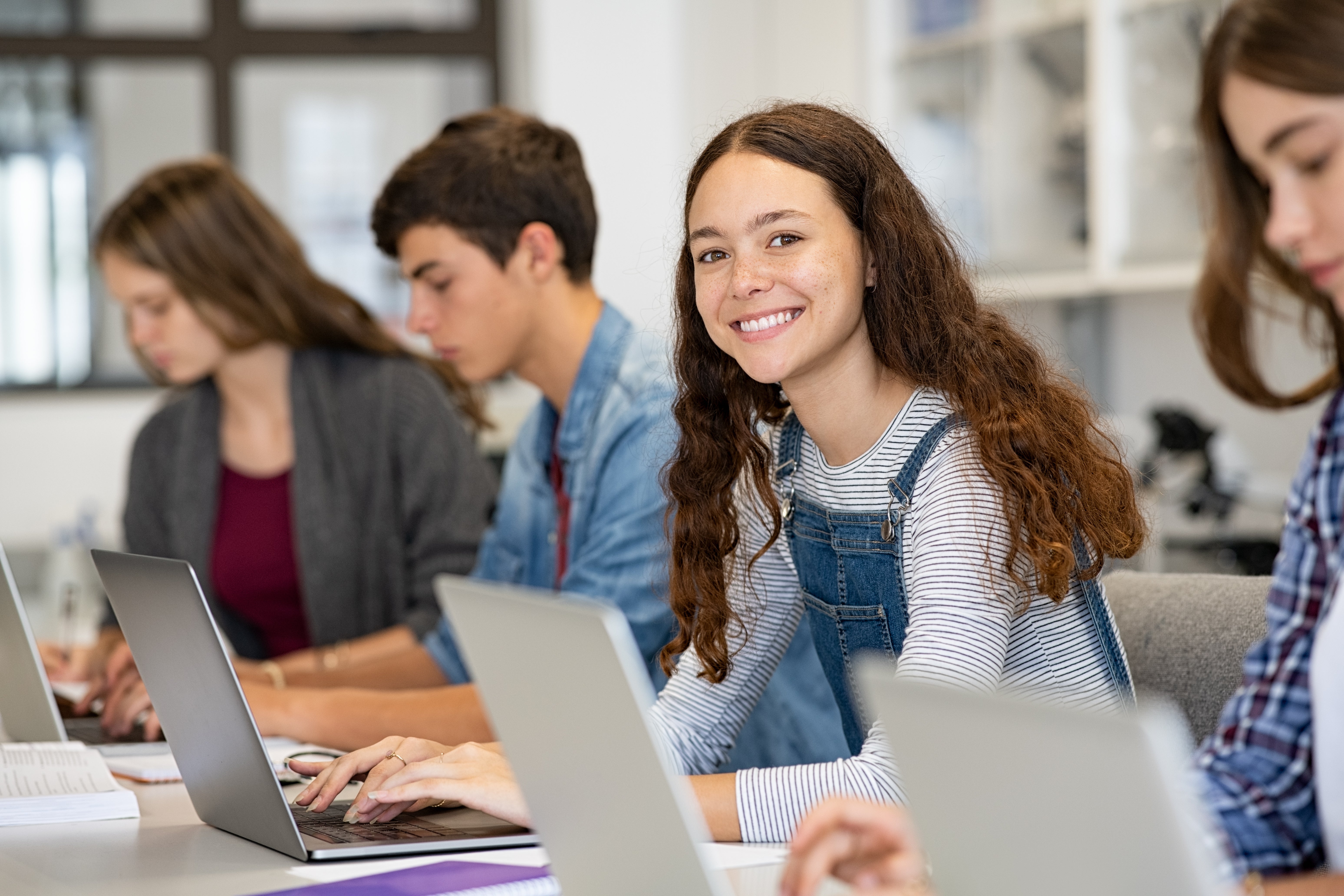 Student with laptop in classroom