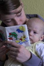 Adult reading book to baby