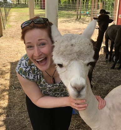 A picture of PI Rachel Romeo with an alpaca