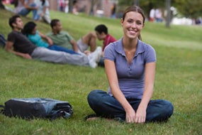 Woman sitting on grass on campus
